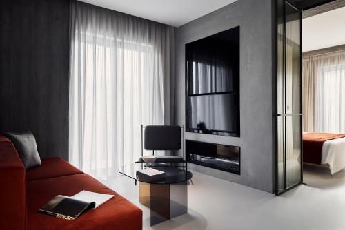 a living room with a red couch and a television at The Newel Metaxourgeio in Athens