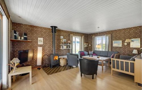 a living room with a fireplace and a brick wall at Holiday Home Clemmessti in Klitmøller