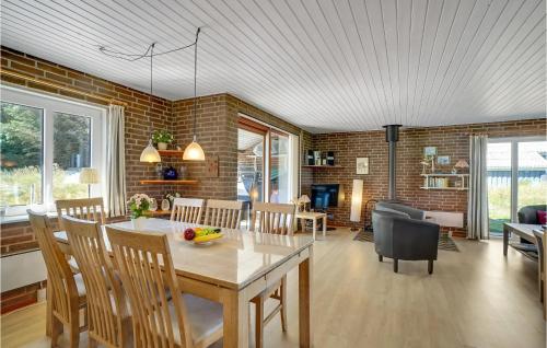 a dining room and living room with a table and chairs at Holiday Home Clemmessti in Thisted