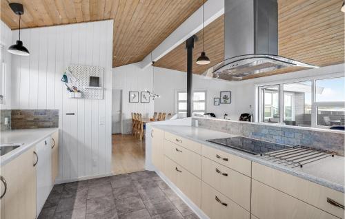 VestervigにあるBeautiful Home In Vestervig With 4 Bedrooms, Sauna And Indoor Swimming Poolの白いキャビネットと木製の天井が備わるキッチン