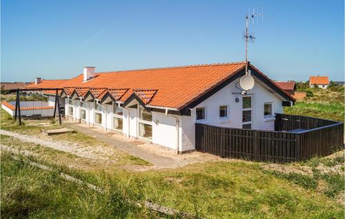 a house with an orange roof and a black fence at Amazing Home In Thisted With Sauna in Klitmøller