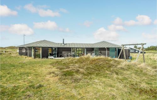 a house on top of a grassy hill at Stunning Home In Thisted With Sauna in Klitmøller