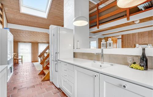 クリムトラにあるAmazing Home In Thisted With 3 Bedrooms And Saunaの白いキャビネットとアーチ型の天井が備わるキッチン