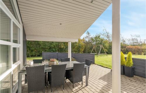 a patio with a table and chairs on it at Holiday Home Bellisvænget Hemmet Denm in Falen