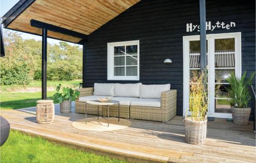 a patio with a couch on a wooden deck at Hygihytten in Hemmet