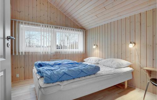 a bed in a room with wooden walls and a window at Nice Home In Hovborg With Kitchen in Hovborg
