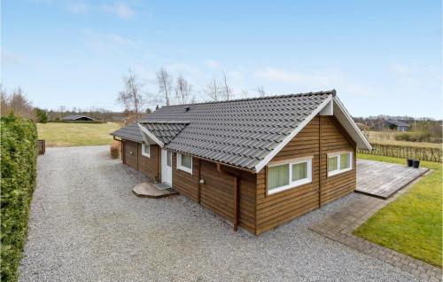a small cabin with a roof on a gravel driveway at Nice Home In Hovborg With Kitchen in Hovborg