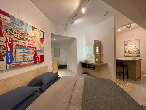 Vouliagmeni Art Micro Loft في أثينا: غرفة نوم فيها سرير ومكتب