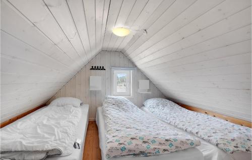 TarmにあるBeautiful Home In Tarm With 5 Bedrooms, Sauna And Wifiのベッドルーム(ベッド2台付)が備わる屋根裏部屋です。