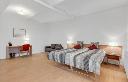 a bedroom with a bed and a couch and a chair at Lønborggaard in Hemmet