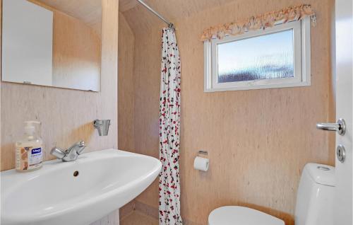 ein Bad mit einem Waschbecken, einem WC und einem Fenster in der Unterkunft Amazing Home In Struer With Kitchen in Remmer Strand