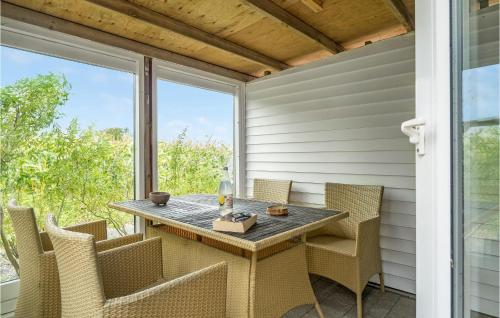 a table and chairs on the back porch of a house at Stunning Apartment In Thisted With Wifi in Thisted