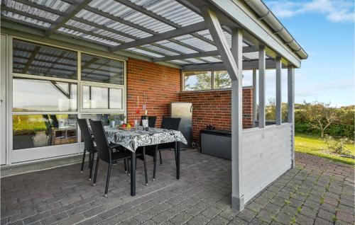 a patio with a table and chairs under a pergola at Cozy Home In Vinderup With Wifi in Vinderup