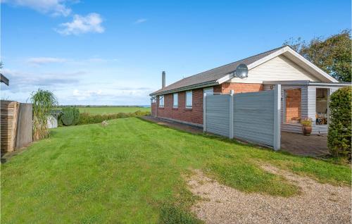 a brick house with a fence in the yard at Cozy Home In Vinderup With Wifi in Vinderup