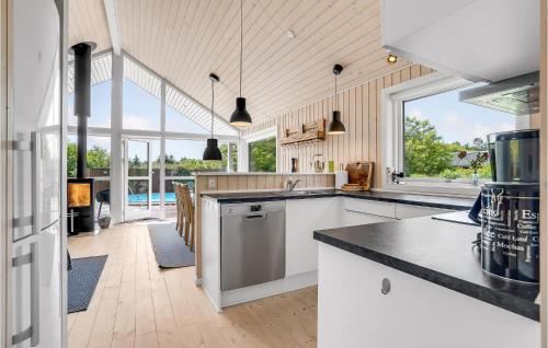 a kitchen with white cabinets and a large window at Gorgeous Home In Vemb in Vemb