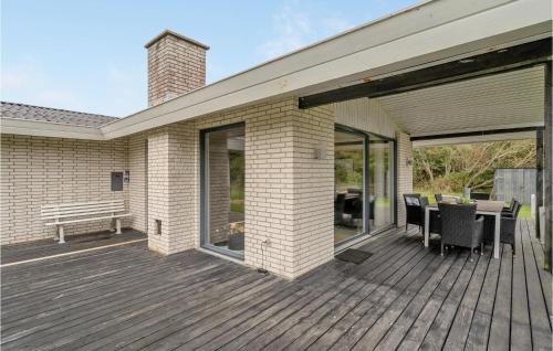 a wooden deck with a table and a bench on it at 3 Bedroom Amazing Home In Hurup Thy in Sindrup