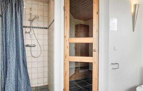 a bathroom with a shower with a wooden door at Nice Home In Hurup Thy With House A Panoramic View in Sindrup