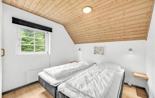 HusbyにあるNice Home In Ulfborg With Kitchenの木製の天井の客室のベッド1台分です。