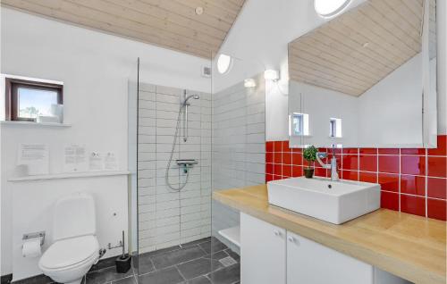 y baño con aseo blanco y lavamanos. en Awesome Home In Thyholm With 3 Bedrooms, Sauna And Wifi, en Thyholm