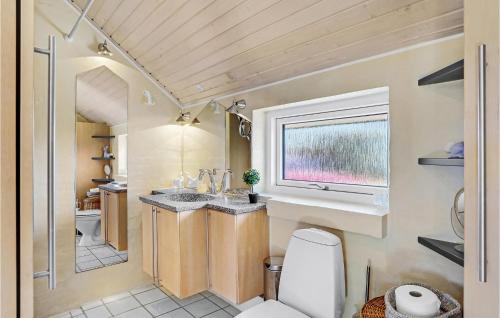 a bathroom with a toilet and a sink and a window at Beautiful Home In Struer With House Sea View in Struer