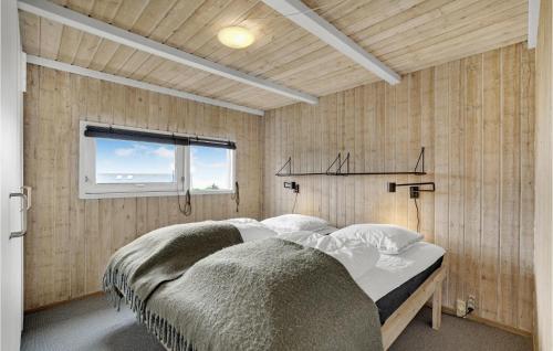 1 dormitorio con 1 cama en una pared de madera en Udsigten en Lemvig