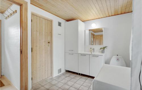 Sejerslevにある3 Bedroom Awesome Home In Nykbing Mの白いキャビネットと木製の天井が備わるバスルーム