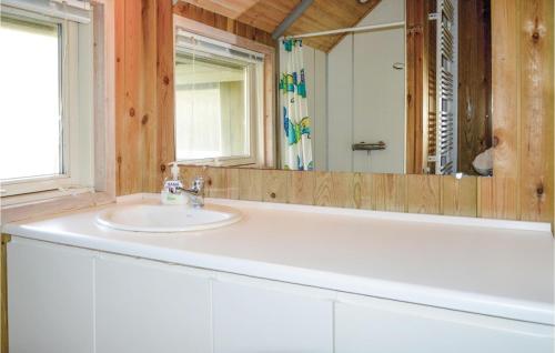 uma casa de banho com um lavatório branco e um espelho. em Beautiful Home In Ringkbing With Kitchen em Søndervig