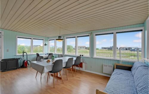 a living room with a table and chairs and windows at Holiday Home Vinderup 5 in Vinderup