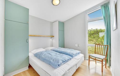 1 dormitorio con 1 cama, 1 silla y 1 ventana en Amazing Home In Ringkbing With House A Panoramic View, en Søndervig