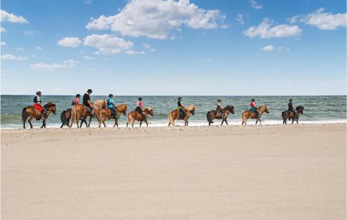 a group of people riding horses on the beach at Cozy Home In Hanstholm With Kitchen in Hanstholm
