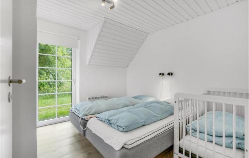 ØhuseにあるBeautiful Home In Ulfborg With 4 Bedrooms, Sauna And Wifiの白いベッドルーム(ベッド1台、窓付)