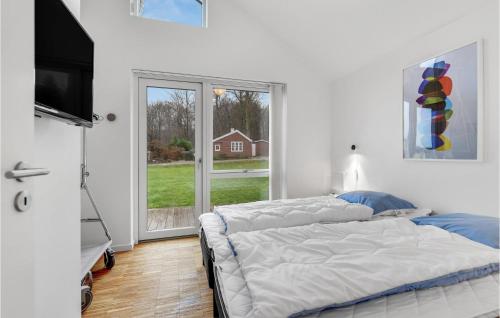 a bedroom with two beds and a large window at 3 Bedroom Cozy Home In Haderslev in Kelstrup Strand