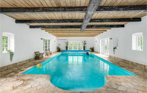 an indoor swimming pool with blue water in a house at Nice Home In Sjlund With Kitchen in Sønder Bjert