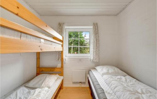 two bunk beds in a room with a window at Gorgeous Home In Ulfborg With Private Swimming Pool, Can Be Inside Or Outside in Øby