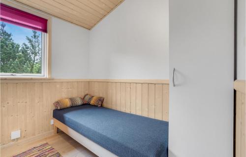 a small bed in a room with a window at Holiday Home Blåbærstien Fjerritslev Iii in Torup Strand