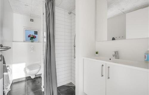 Baño blanco con aseo y lavamanos en Awesome Home In Ringkbing With Kitchen, en Søndervig