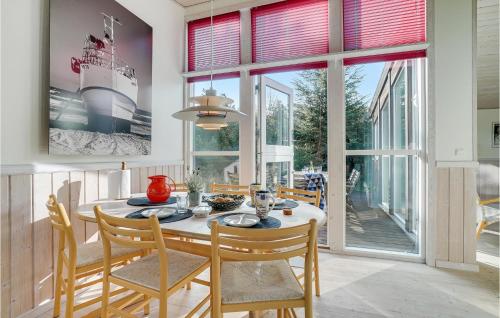 a dining room with a table and chairs at Holiday Home Blåbærstien Fjerritslev Iii in Torup Strand