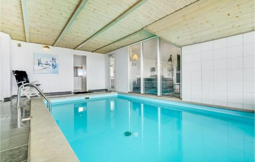 a swimming pool with blue water in a house at Nice Home In Ringkøbing With Sauna in Søndervig