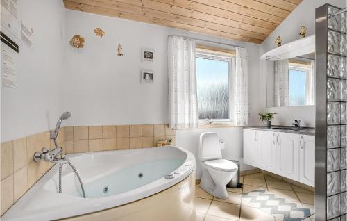 Lild StrandにあるAmazing Home In Frstrup With 4 Bedrooms, Sauna And Wifiの白いバスルーム(バスタブ、トイレ付)