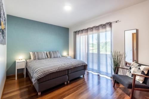 um quarto com uma cama e uma grande janela em Bay View-T1 em São Martinho do Porto