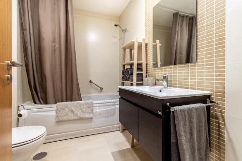 uma casa de banho com um lavatório, um WC e um espelho. em Bay View-T1 em São Martinho do Porto