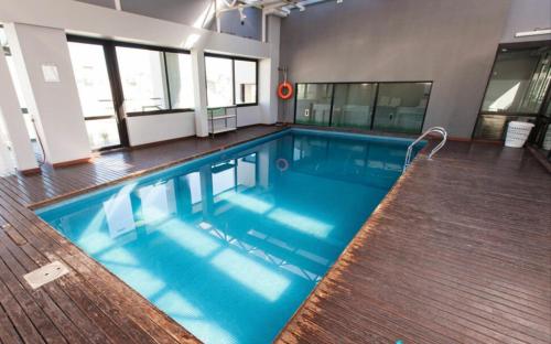ein großer Pool mit blauem Wasser in einem Gebäude in der Unterkunft Buenos Aires Apartamento in Buenos Aires