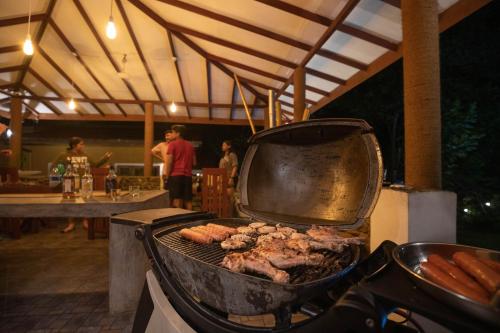 a grill with meat and sausages on top of it at Kuru Ganga Villa in Eratnagoda