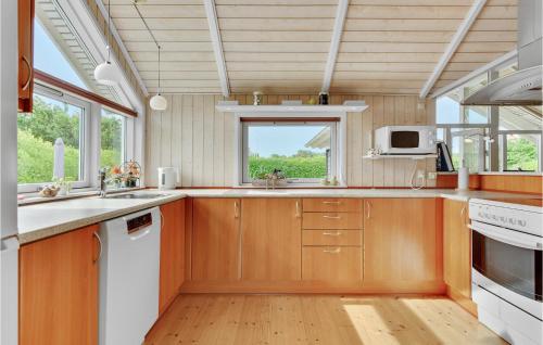 a kitchen with wooden cabinets and a window at Holiday Home Lindevej Broager Ix in Broager