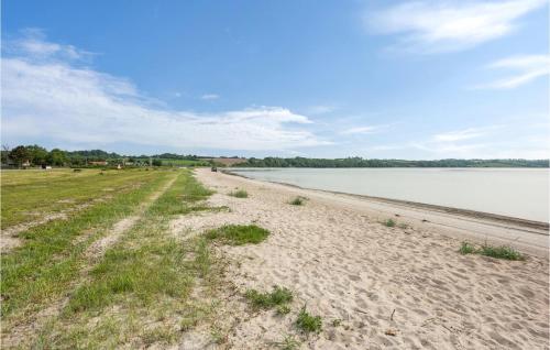 a sandy beach next to a large body of water at Holiday Home Lindevej Broager Ix in Broager