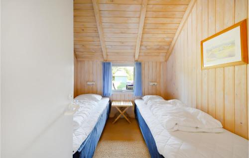 two beds in a small room with a window at Holiday Home Tulipanvej Fjerritslev I in Slettestrand