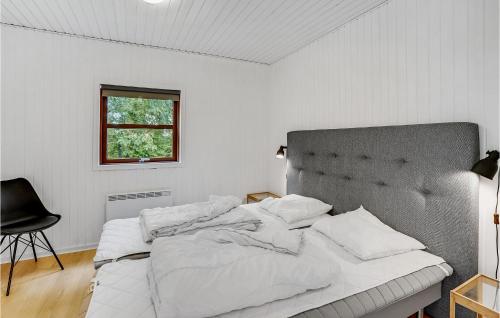 Cozy Home In Haderslev With Kitchen في Kelstrup: غرفة نوم بيضاء مع سرير كبير مع شراشف بيضاء