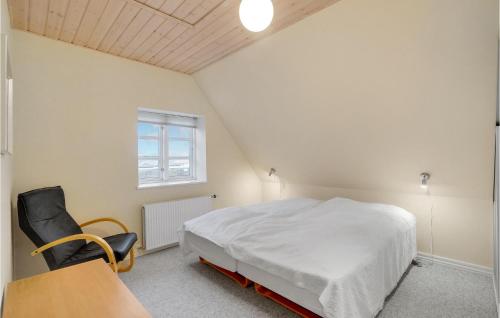 a bedroom with a bed and a chair and a window at Nice Home In Thyborøn With Wifi in Thyborøn