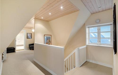 an attic hallway with a staircase and a window at Nice Home In Thyborøn With Wifi in Thyborøn