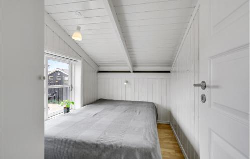 a bed in a white room with a window at 5 Bedroom Amazing Home In Haderslev in Flovt